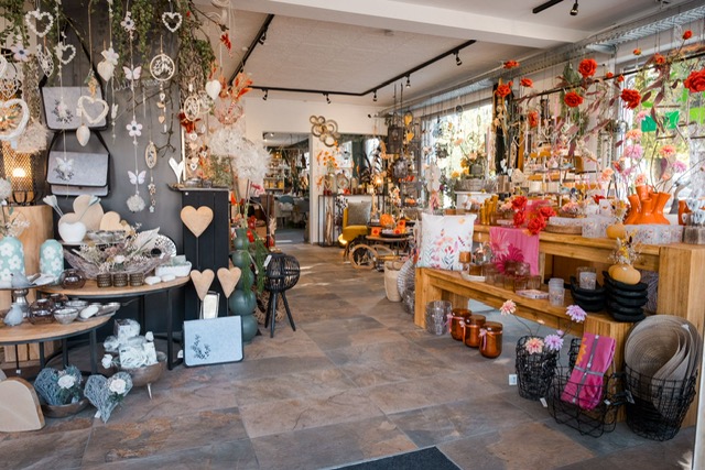 Dekorationsbereich mit Holzherzen und hängenden Ornamenten im Decoart'S