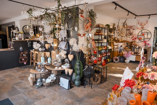 Verkaufsraum mit Pflanzen, Weidenkörben und Regalen mit Produkten