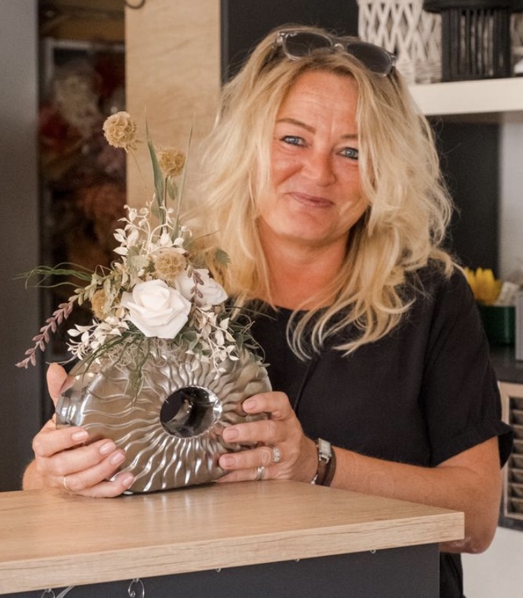 Inhaberin Silke Schöllhammer mit einer dekorierten Vase in ihrem Geschäft